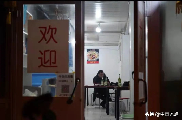 2021年除夕夜，一名顺丰骑手在居住的城中村里一家小饭馆独自过年。王嘉兴/摄