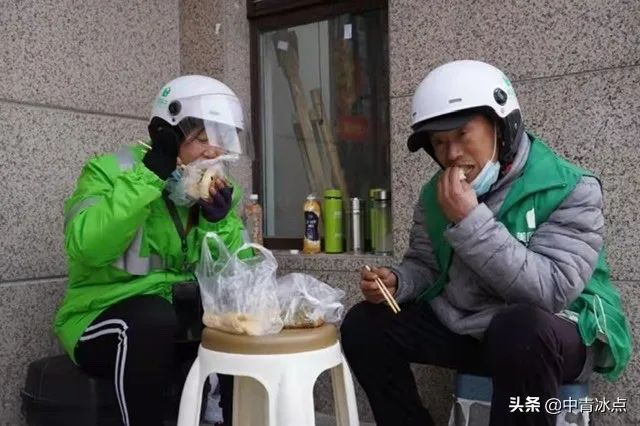 两名骑手在送餐间隙吃饭。王嘉兴/摄