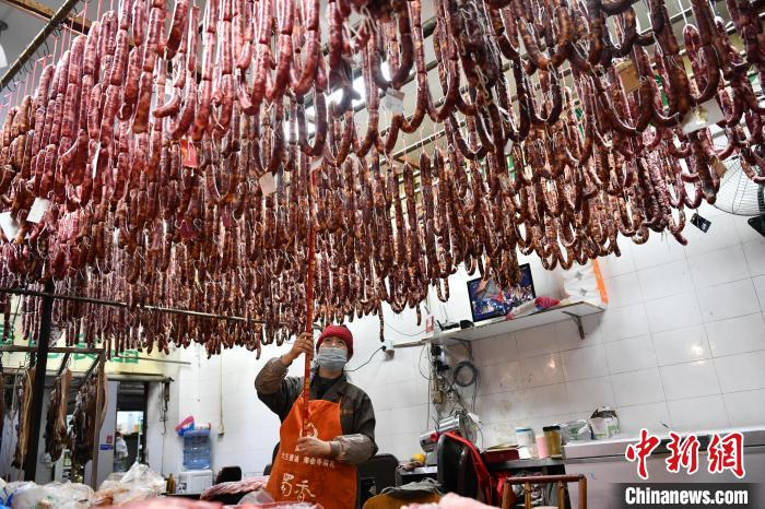 一条条挂有口味、货主名纸片的油亮香肠从天花板垂下。　张浪 摄