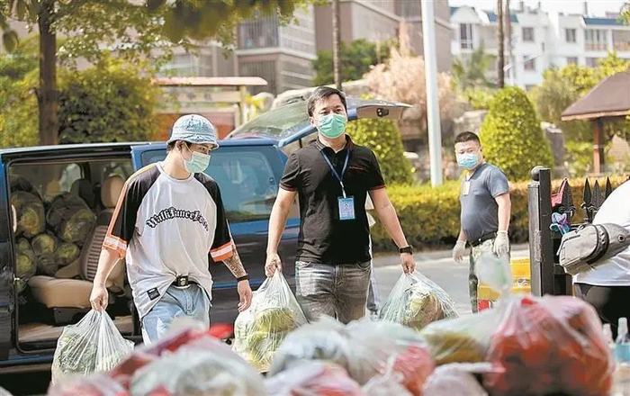 网格员张金峰搬运小区住户团购的蔬菜。图自云南网