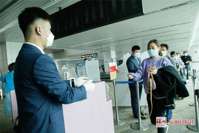 搭乘首航班机的旅客有序排队检票上机