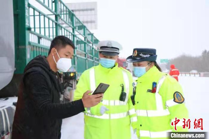图为甘肃张掖市九龙江高速大队交警查看驾驶人健康码。　刘学竞 摄