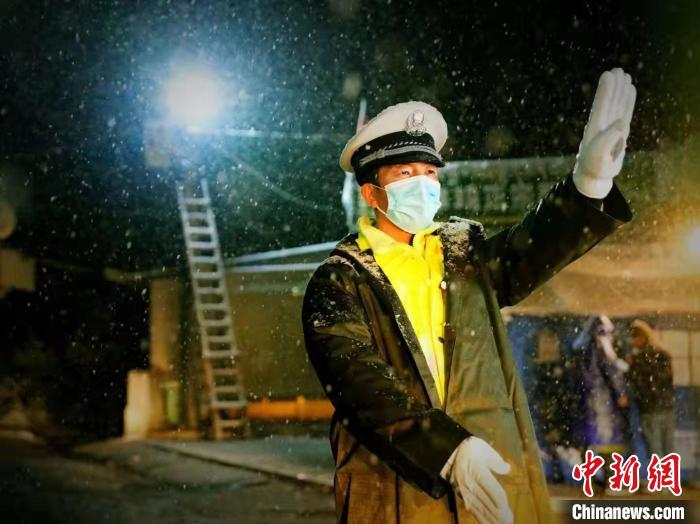 图为甘肃甘南州临潭县交警在风雪“疫”线执勤。　苏珺霞 摄