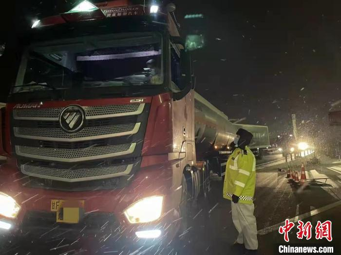 图为甘肃酒泉市肃州区交警风雪夜中执勤保畅通。　李亚萍 摄