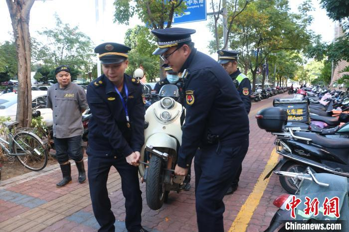 执法人员对非外卖、快递车辆乱停“专属”车位行为进行查处，将车辆拖离。　林馨 摄