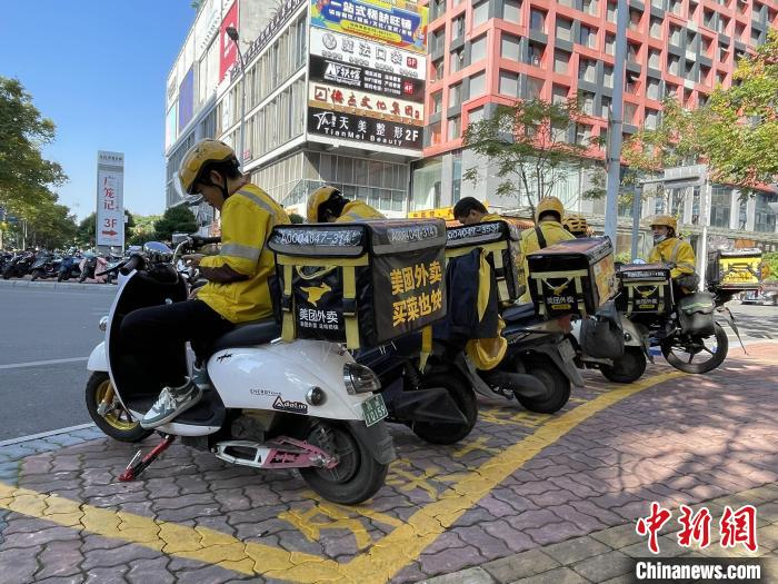 外卖骑手在“专属”停车位上休息。　林馨 摄