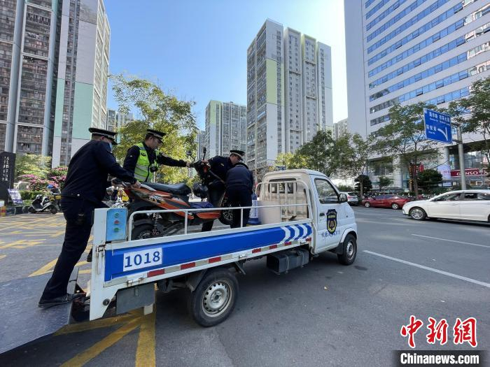 执法人员对非外卖、快递车辆乱停“专属”车位行为进行查处，将车辆拖离。　林馨 摄