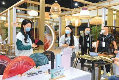 以“绿色低碳，共同富裕”为主题的第14届中国义乌国际森林产品博览会近日在浙江义乌国际博览中心举行。图为采购商在采购竹制工艺扇。龚献明摄（人民视觉）