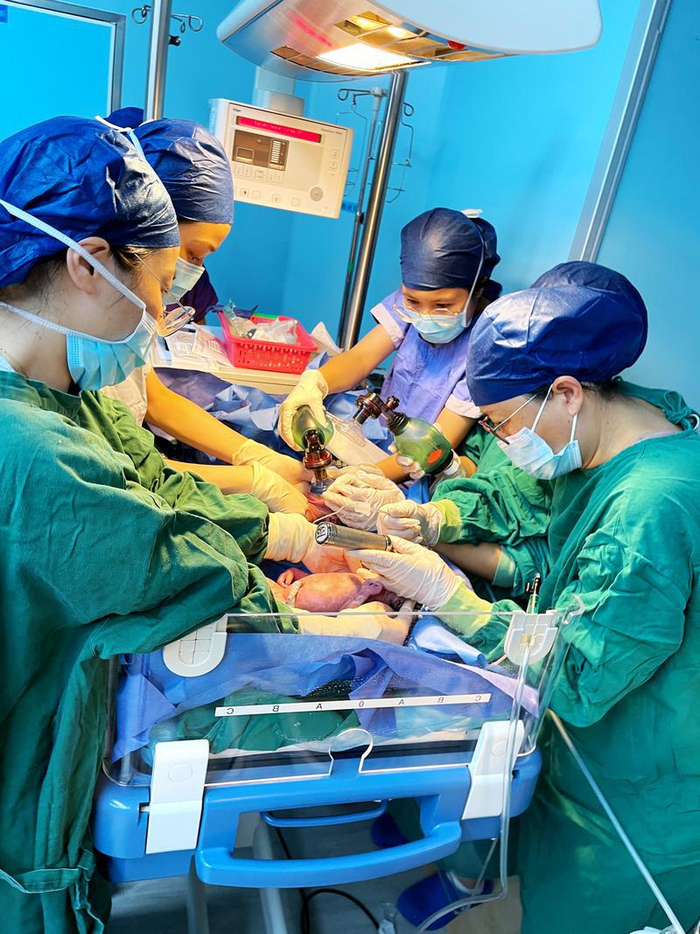 ▲在辐射台上给三个宝宝进行抢救的儿科医护。