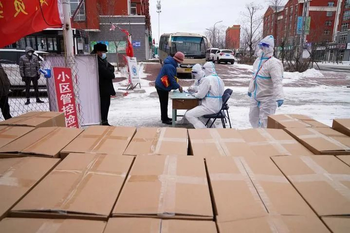 11月10日，在黑龙江省黑河市一小区，社区工作人员为居民发放免费生活物资。新华社记者王松 摄