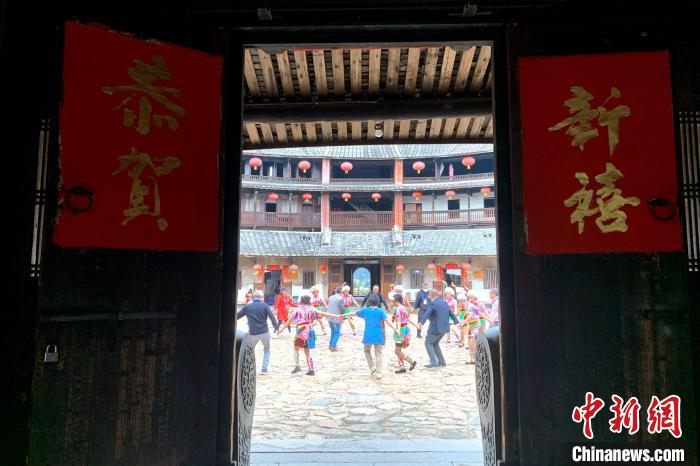 前来漳州参访的海外华文媒体代表在二宜楼内与景区工作人员跳舞互动。　王东明 摄