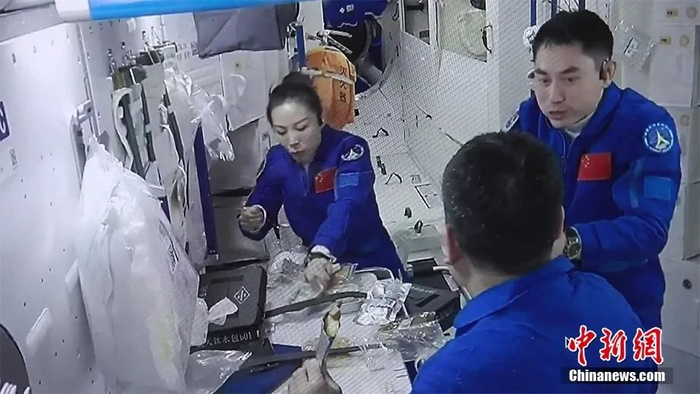 资料图：三名航天员吃午餐。（视频截图）图片来源：视觉中国