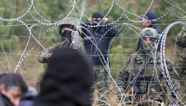 图说：铁丝网那端，士兵用化学喷雾驱散难民。图源：AP