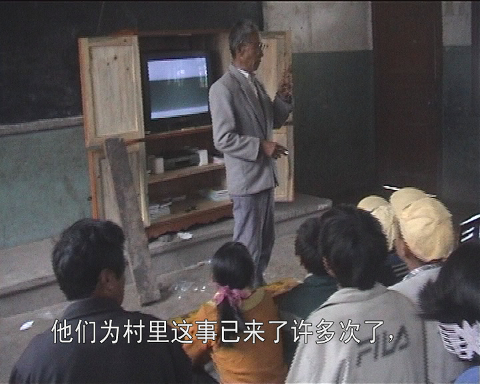 茨中村放映活动中，刘文增老师在电教室讲述天主教在茨中的历史。（素材记录截图）