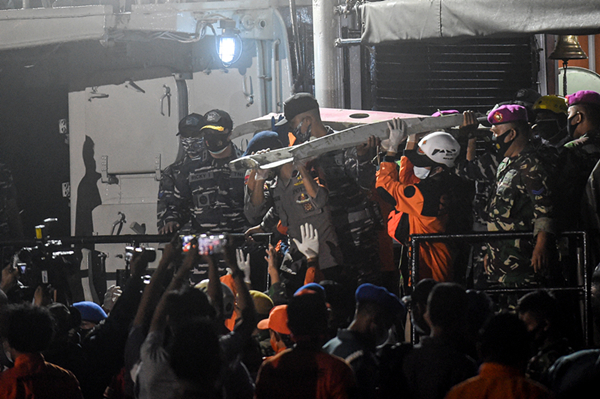 图说：1月10日，搜救人员在印度尼西亚雅加达戈戎不碌港搬运失事客机残骸。