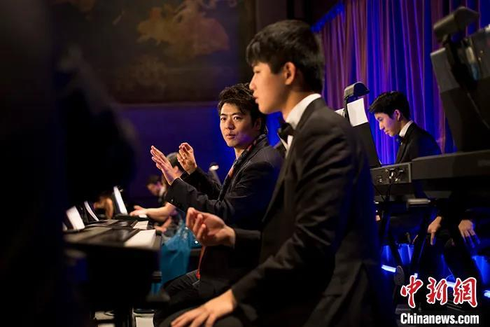 图为2018年10月10日，郎朗国际音乐基金会支助的青少年钢琴家与郎朗在纽约演奏钢琴曲目。 中新社记者 廖攀 摄