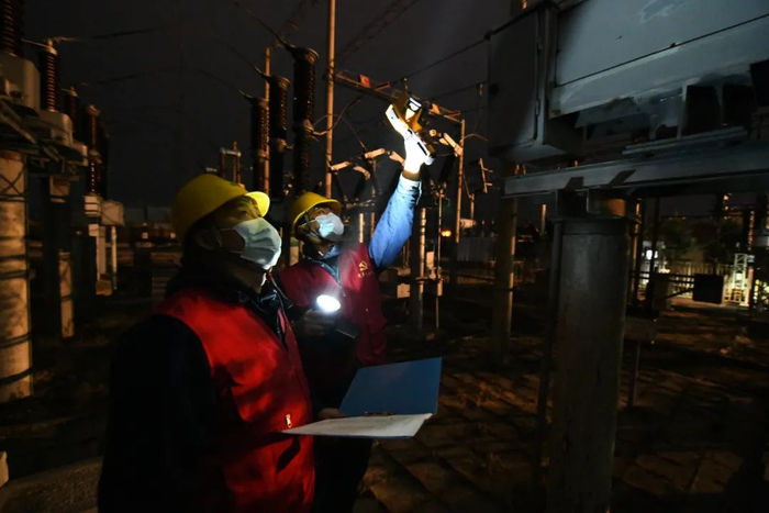 图：11月21日晚，国网虎林市供电分公司输变电工区运行人员袁汇海、陈思宇在66千伏虎林变电站1号主变接点进行测温。