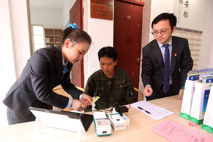 农行天台支行工作人员在后岸村帮助村民办理业务（央广网记者 魏炜摄）