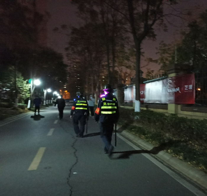 ▲11月23日19时，两名保安正拿着警棍在小区内巡逻。 新京报记者 吴梦真 摄