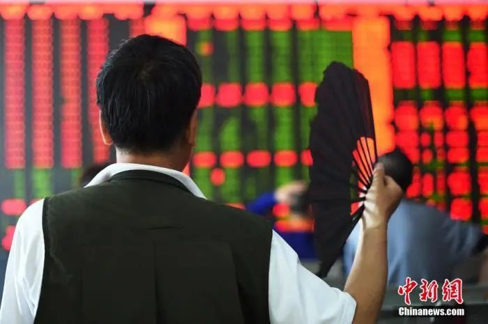 资料图：股民一边摇扇一边关注股市大盘。中新社发 武俊杰 摄