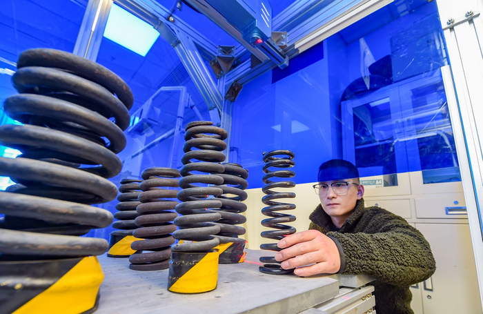 （景曜智能科技的研发人员操作3D视觉检测站对铁道弹簧进行故障检测）