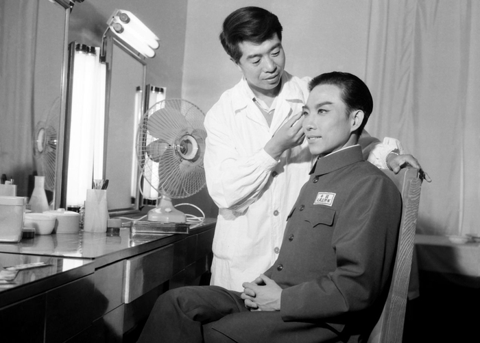 《奇袭白虎团》工作照，张立棠为主演宋玉庆化妆。&nbsp;长影供图。