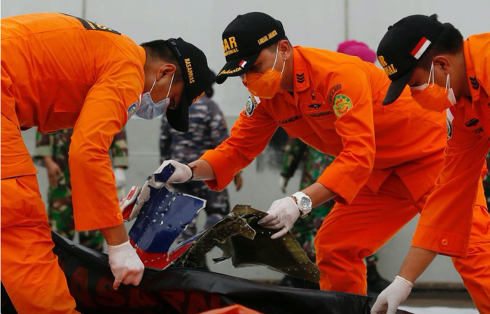 印尼救援人员在检查失事飞机的残骸。（图源：路透社）