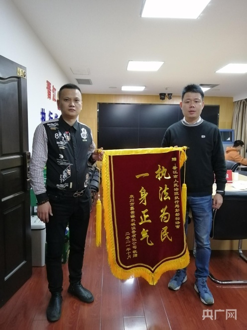 吴某将写有“执法为民，一身正气”的锦旗赠予执行干警彭劲松（央广网发 苏荣喻摄）