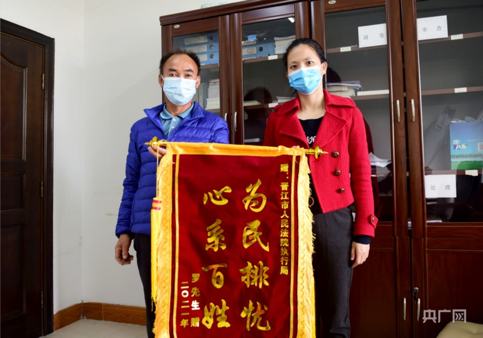 罗某将写有“为民排忧，心系百姓”的锦旗赠予执行干警庄婷婷（央广网发 苏荣喻摄）