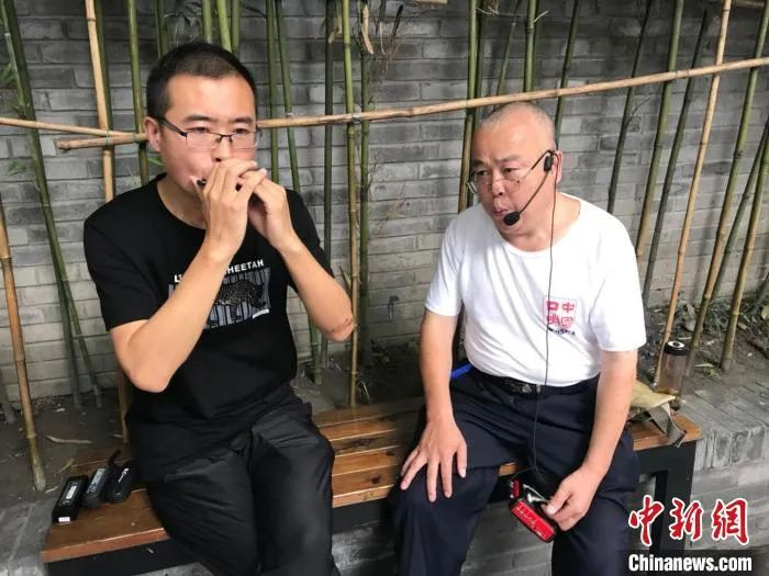 成都“口哨大爷”和乐队成员在成都街头路演。岳依桐 摄