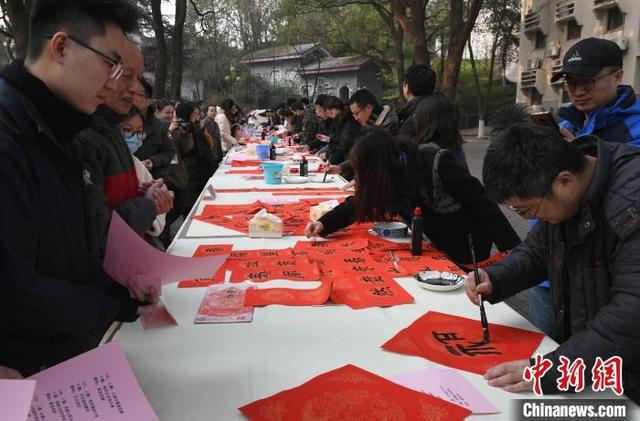 图为西南大学教授现场为师生及家属写福字。 周毅 摄