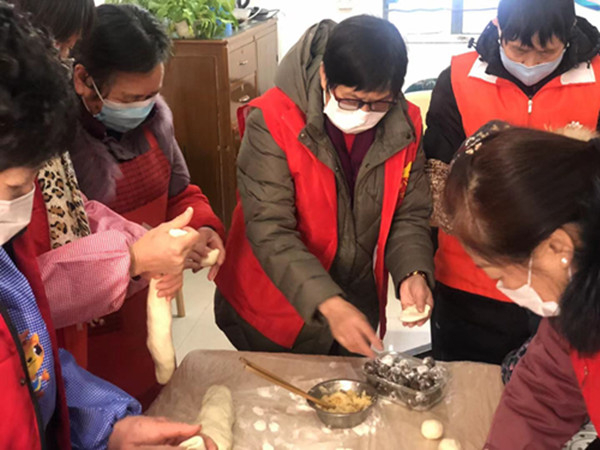 图说：志愿者们忙着蒸包子。