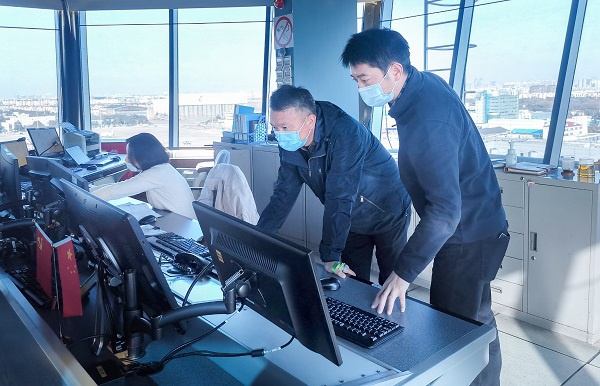 图说：华东空管局副局长熊飞（中）在虹桥塔台指导