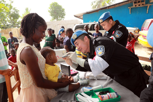 　　2017年12月28日，在利比里亚蒙罗维亚，中国第五支驻利比里亚维和警察防暴队医护人员为本森威尔社区孤儿院的儿童和员工进行义诊。新华社发（赵小新摄）