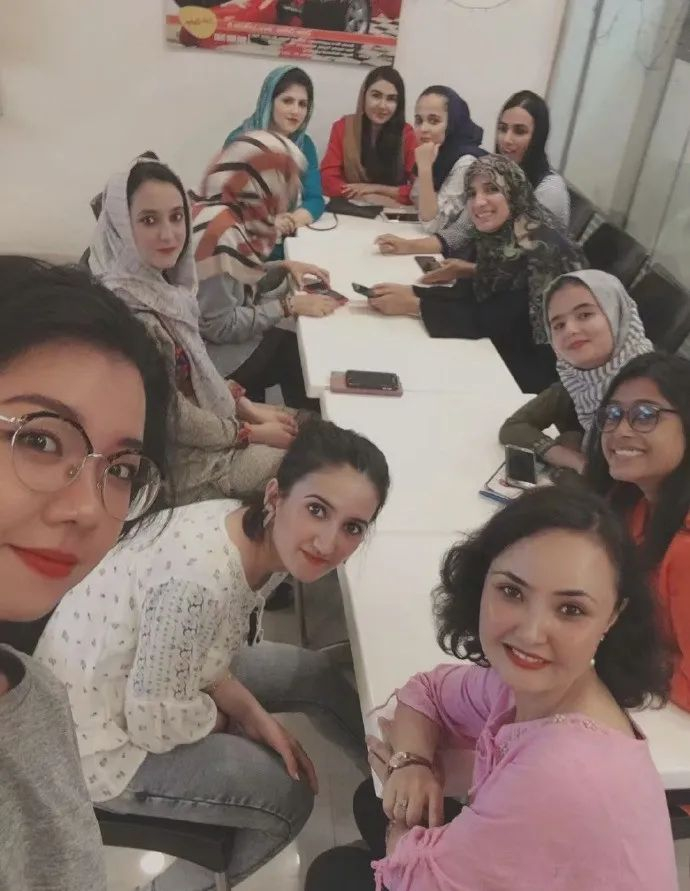 小陈的阿富汗室友过生日，一群人坐在一起等蛋糕。（受访者供图）