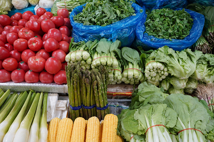 新市菜市场，摊主每天用一两个小时码放菜品。