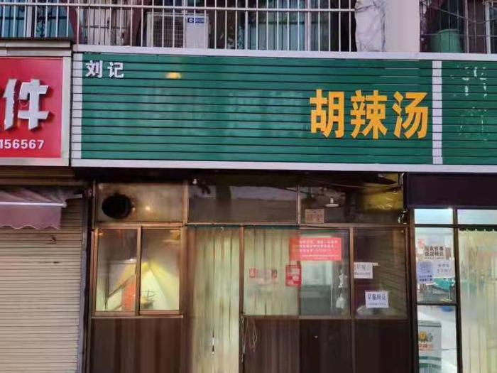 担心侵权，一些商户将“逍遥镇”三字拆掉了。摄影：朱恩民