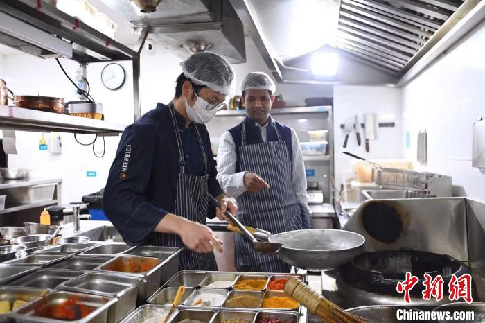 博文正在指导餐厅的厨师烹饪新菜。　安源 摄