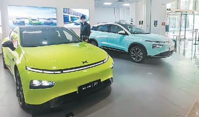 图为12月3日一早，位于北京市朝阳区金地广场的小鹏汽车专卖店内，工作人员正在对展示车型进行检查，准备开张迎客。本报记者 王俊岭摄