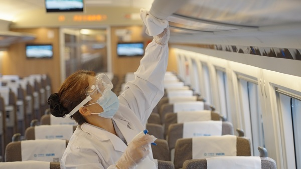  图说：工作人员在列车上清洁消毒