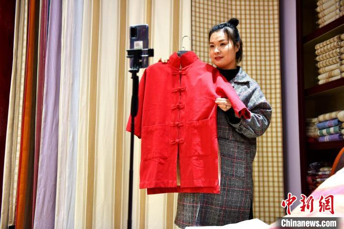 工作人员在河北省衡水市冀州区田园棉文化园销售展区对粗布家居产品进行现场直播。　辛培 摄