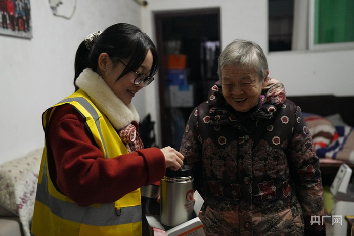志愿者张婷正在教蔡奶奶如何使用焖烧杯（央广网发 胡琪蓉 摄）