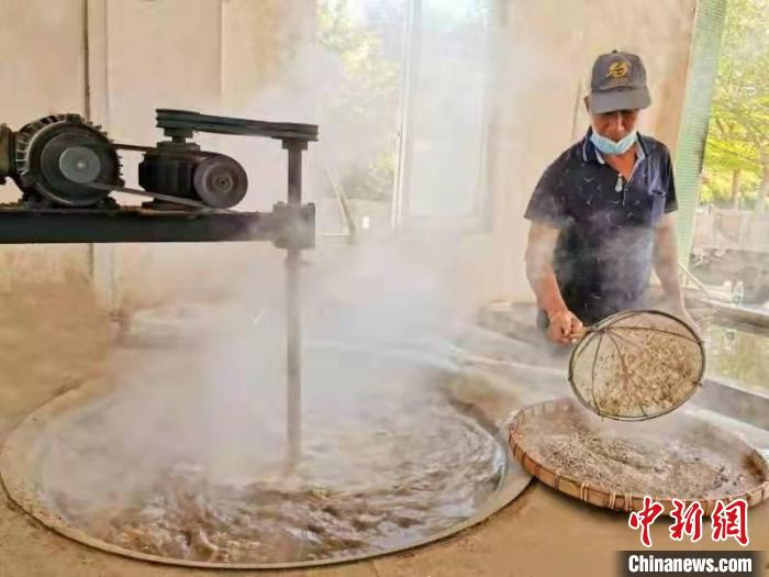 煮蚬借助马达带动搅拌，便于蚬肉浮出水面 李晓春 摄