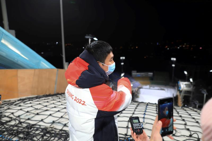 12月12日晚，工作人员在首钢滑雪大跳台的出发区介绍造雪情况。新京报记者 浦峰 摄