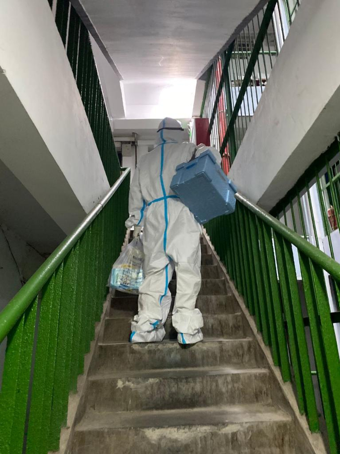 基层医务人员阚丽艳上门采样工作间隙在楼道内短暂休息。（杭州市拱墅区卫生健康局供图）
