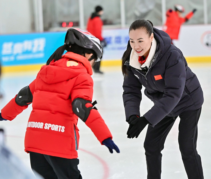 10月22日，陈露帮助上冰体验的孩子训练。受访者供图