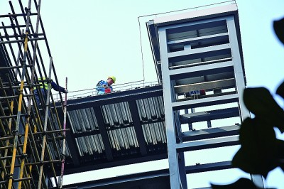 　　安徽合肥蜀山区天一家园小区，工人在为居民楼加装电梯。方好摄/光明图片
