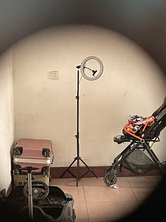 透过杜可心和王言家门上的小孔可以看到，家里摆着儿童推椅和打光灯。