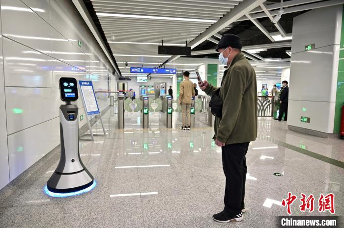图为南宁地铁5号线广西大学站内，智能问询机器人吸引市民拍摄。　俞靖 摄