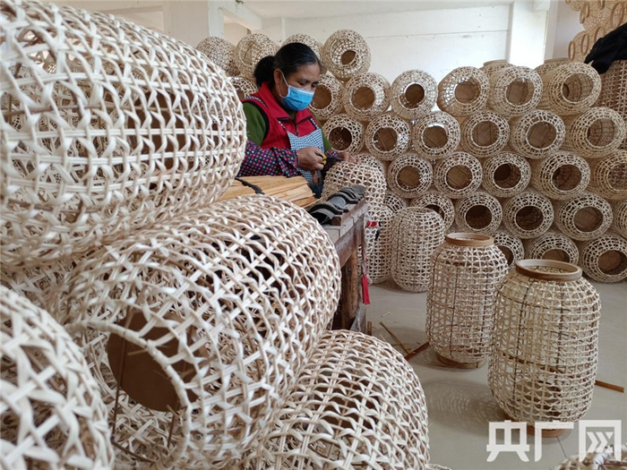 工人正对竹灯罩进行修剪加工（央广网发 记者吴良艺摄）